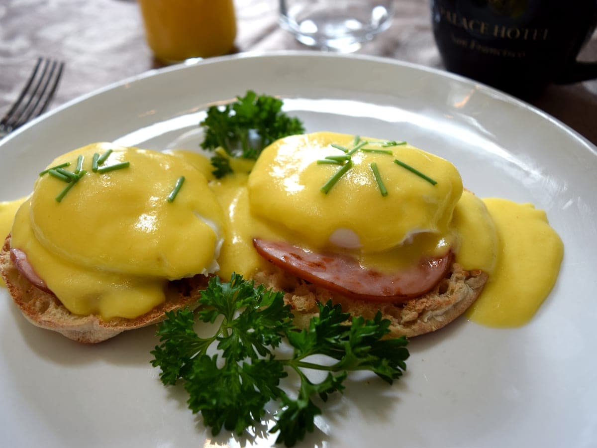 Traditional eggs Benedict — poached eggs, Canadian bacon, hollandaise on an English muffin.